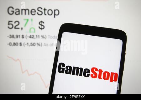 In questa illustrazione fotografica un logo GameStop è visto sullo schermo di un telefono cellulare davanti al prezzo di stock e un grafico. Foto Stock