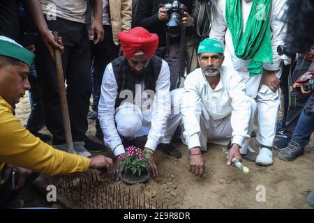 Nuova Delhi, India. 05 febbraio 2021. Manifestanti che piantano seghe durante la dimostrazione degli agricoltori. Per oltre due mesi a Ghaizipur (confine di Delhi-Utttar Pradesh), migliaia di agricoltori che protestano chiedono un'agitazione a livello nazionale (Chakka Jam) ad eccezione di Delhi, Uttar Pradesh e Uttarakhand per rafforzare le loro richieste di abrogazione delle leggi agricole, contro misure repressive, compresa la sospensione di Internet, filo di rasoio su file di pesanti barricate di ferro, barricate di cemento, pareti di cemento e punte di ferro e chiodi posti su tutto il sito principale di protesta. Credit: SOPA Images Limited/Alamy Live News Foto Stock