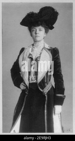 Sig.ra Alice Roosevelt Longworth, tre quarti di lunghezza verticale, in piedi con la mano destra sulla hip, indossando il cappotto e hat Foto Stock