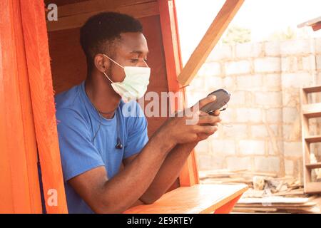 un giovane uomo d'affari africano che usa una macchina pos Foto Stock