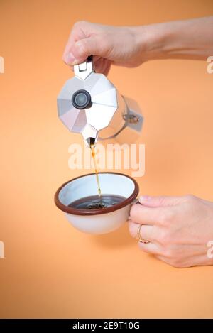 Donna che versa il caffè in una tazza, dettaglio Foto Stock