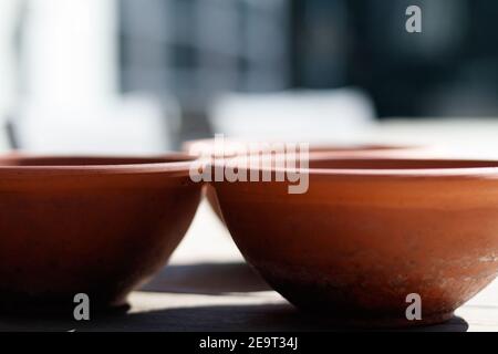 Tre vasi di piante di terracotta su un tavolo, che colano ombre, con fuoco selettivo Foto Stock