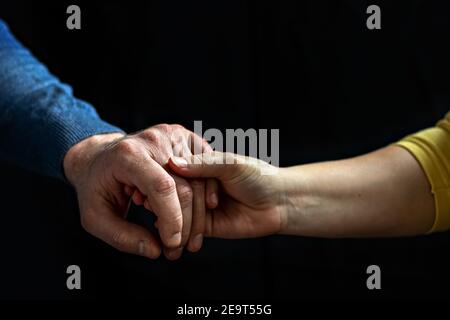 Giovane coppia che tiene le mani mostrando amore e cura, marito e moglie sono teneramente vicini insieme, mostrando sostegno e comprensione. Foto Stock