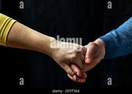 Giovane coppia che tiene le mani mostrando amore e cura, marito e moglie sono teneramente vicini insieme, mostrando sostegno e comprensione. Foto Stock