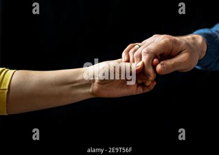 Giovane coppia che tiene le mani mostrando amore e cura, marito e moglie sono teneramente vicini insieme, mostrando sostegno e comprensione. Foto Stock