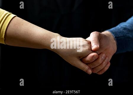 Giovane coppia che tiene le mani mostrando amore e cura, marito e moglie sono teneramente vicini insieme, mostrando sostegno e comprensione. Foto Stock