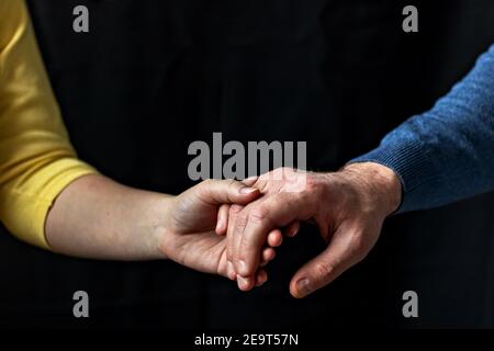 Giovane coppia che tiene le mani mostrando amore e cura, marito e moglie sono teneramente vicini insieme, mostrando sostegno e comprensione. Foto Stock