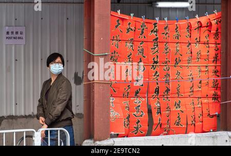 Hong Kong, Cina. 06 febbraio 2021. HONG KONG, HONG KONG SAR, CINA: 6 FEBBRAIO 2021. Una calligrafia sifu (master) lavora sul lato di una strada trafficata in Causeway Bay Hong Kong producendo coppie Cantonesi dipinti a mano pronti per il Capodanno cinese. I couplets di Capodanno lunare o il lyun di cheun, sono usati come decorazione e hanno differenti messaggi auspicious scritti su loro. CNY inizierà venerdì 12 febbraio 2021 con la festa che inaugurerà l'anno zodiacale dell'Ox Alamy Live News/Jayne Russell Credit: Jayne Russell/Alamy Live News Foto Stock