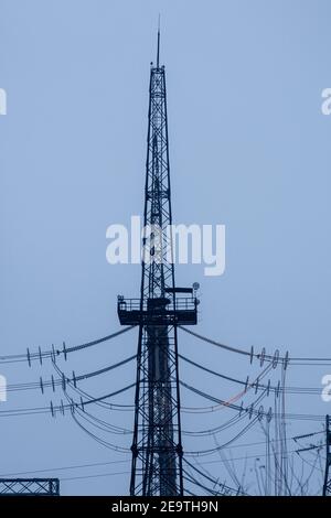 Torre di una linea elettrica ad alta tensione. Cavi rossi caldi. Foto verticale. Foto Stock