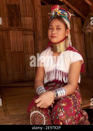 Pose di una donna tribale di Karen Hill con braccialetti di gioielli in entrambe le mani e una collana unica intorno al suo lungo collo Foto Stock