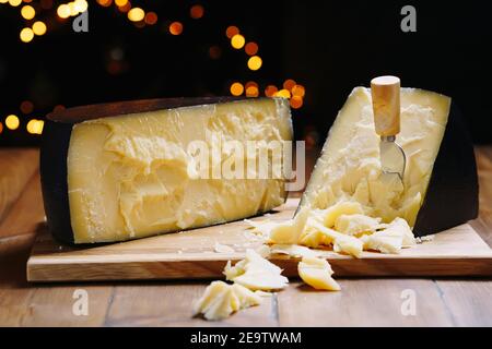 Parmigiano medio duro su tavola di legno, con cavetti parmigiano al formaggio. Foto Stock