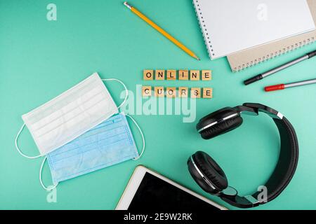 Corso online. La frase è scritta in lettere di legno. Vista dall'alto. Motivazione. Copy space.Tablet, cancelleria per cuffie. Apprendimento a distanza. Scheda Foto Stock