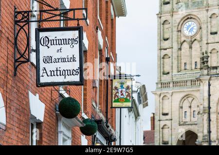 WARWICK, Regno Unito - 15 febbraio 2013. Antico negozio di antiquariato e cartello pub sulla storica Church Street a Warwick, Warwickshire Foto Stock