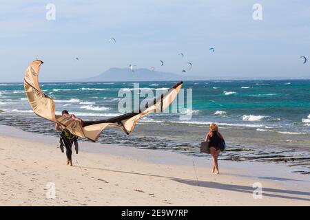 FUERTEVENTURA, SPAGNA - 10 maggio 2013. Coppia di kite surf che cammina sulla spiaggia a Corralejo, Fuerteventura, Isole Canarie Foto Stock