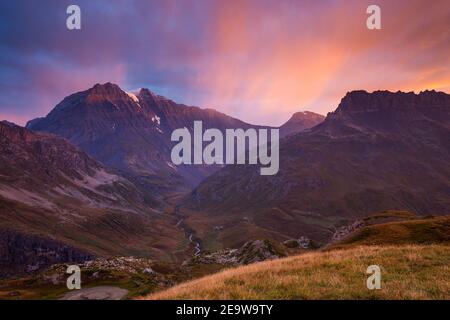 La luce del sole si colora all'alba. Plan du Lac; vallon de la Leisse et Vallon de la Rocheure. La montagna Grande casse. Parc National de la Vanoise. Francia. Europa Foto Stock