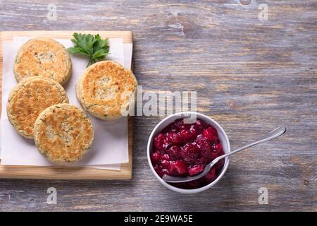 Cotolette di fagioli con erbe, spezie, salsa di frutti di bosco su tavola di legno, stile rustico, vista dall'alto, spazio libero. Delizioso cibo vegetariano Foto Stock