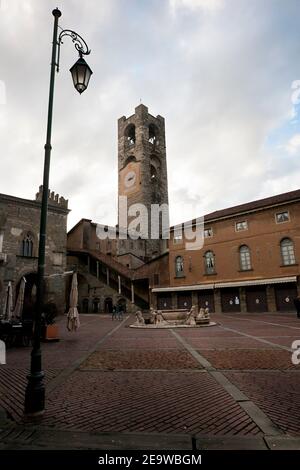 BERGAMO, ITALIA - 05 NOVEMBRE 2019: Fontana con i leoni e la torre dell'orologio su Piazza Vecchia e Torre del comune a Bergamo, Lombardia Foto Stock