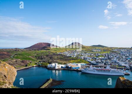 Vista sulla città di Heimaey e sul vulcano Helgafell ed Eldfell In Islanda in una giornata estiva di sole Foto Stock