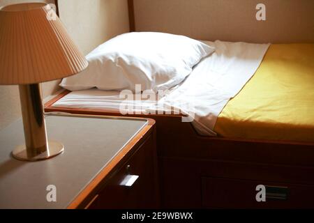 Letto con lampada nella capanna della barca da crociera Foto Stock