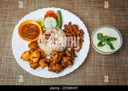 Varietà di cibo nepalese servite insieme sul piatto con yogurt dolce. Teej ko Dar, Teej piatto di cibo speciale, cucina nepalese, riso pulao Foto Stock