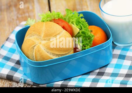 Pranzo in una sana struttura scolastica contenente un rotolo di formaggio, lattuga, pomodoro e satsuma Foto Stock