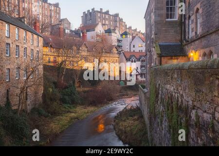 Vista serale sulle acque di Leith e sugli edifici in affito attraverso il centro storico di Dean Village a Edimburgo, Scozia, in un pomeriggio invernale limpido. Foto Stock