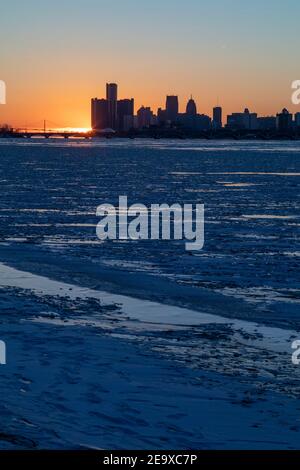 Detroit, Michigan - il fiume Detroit è pieno di ghiaccio invernale mentre il sole tramonta dietro lo skyline del centro. Foto Stock