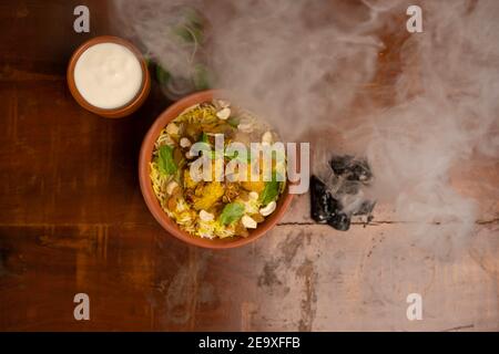 Delizioso pollo piccante biryani, indiano o pakistano ramzan cibo. Su sfondo fumoso. Foto Stock