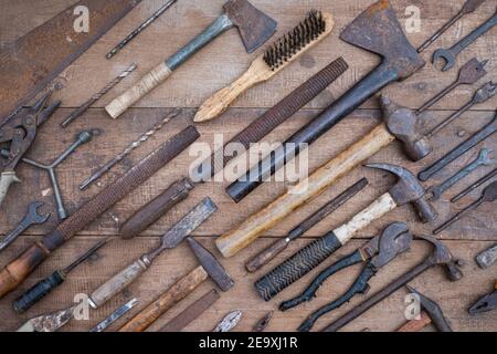 Collezione di antichi utensili a mano per la lavorazione del legno su un banco di lavoro grezzo vecchio legno Foto Stock