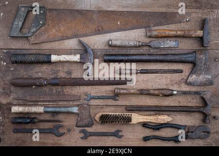 Collezione di antichi utensili a mano per la lavorazione del legno su un banco di lavoro grezzo vecchio legno Foto Stock