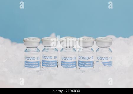 Chiudere i flaconcini di vetro con il vaccino di COVID 19 su ghiaccio in congelatore Foto Stock