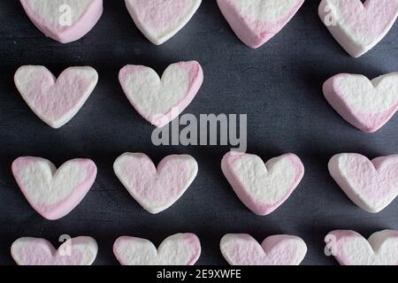 Amore cuore marshmallows visto dalla parte superiore e disposto dentro righe con un cuore mancante da una delle righe Foto Stock