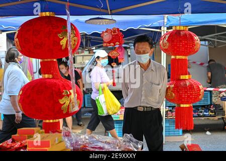 Kuala Lumpur, Malesia. 6 Feb 2021. La gente che indossa le maschere facciali acquista per le decorazioni cinesi di Capodanno ad un mercato in Klang dello stato di Selangor, Malesia, 6 febbraio 2021. Credit: Chong Voon Chung/Xinhua/Alamy Live News Foto Stock