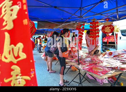 Kuala Lumpur, Malesia. 6 Feb 2021. La gente che indossa le maschere facciali acquista per le decorazioni cinesi di Capodanno ad un mercato in Klang dello stato di Selangor, Malesia, 6 febbraio 2021. Credit: Chong Voon Chung/Xinhua/Alamy Live News Foto Stock