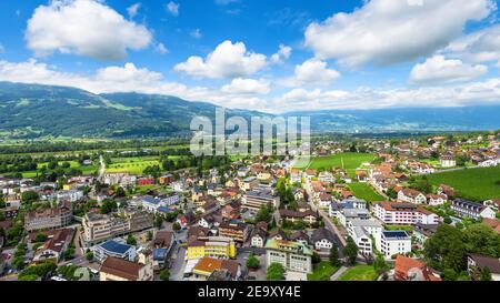 Skyline di Vaduz, principato del Liechtenstein. Vista panoramica aerea della città nelle Alpi svizzere. Panorama di valle verde con città e cielo blu in estate. Foto Stock