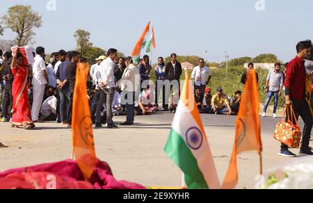 Beawar, Rajasthan, India, 6 febbraio 2021: Pendolari bloccati spostano i dimostranti durante la marmellata di chakka a livello nazionale (protesta di blocco) per sostenere la continua agitazione contro le leggi governative sulla riforma agricola, a Beawar. I manifestanti cantano slogan contro il primo ministro Narendra modi e il suo partito al governo BJP. Le proteste sono state guidate principalmente dagli agricoltori del Punjab e dell'Haryana, anche se oggi migliaia di persone si stanno unendo da altre parti del paese. Credit: Sumit Saraswat/Alamy Live News Foto Stock