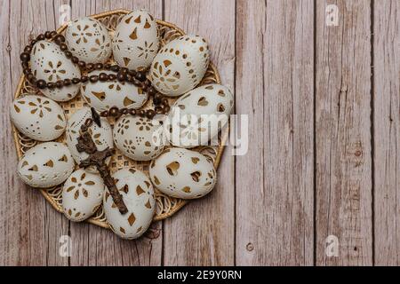 Happy Easter.White mano fatto uova di Pasqua con crocifisso in legno basket.Spring decorazione sfondo. Tradizione festiva per i paesi dell'Europa orientale Foto Stock