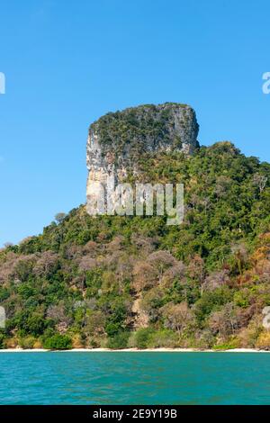 Una gigantesca formazione rocciosa si affaccia sulla sabbia bianca e sul mare blu di Railay Beach, a Krabi, Thailandia Foto Stock