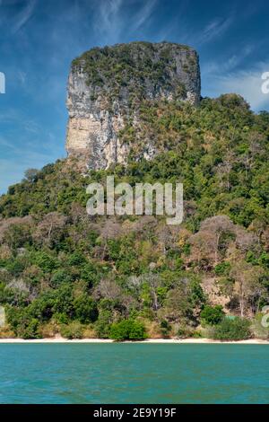 Una gigantesca formazione rocciosa si affaccia sulla sabbia bianca e sul mare blu di Railay Beach, a Krabi, Thailandia Foto Stock