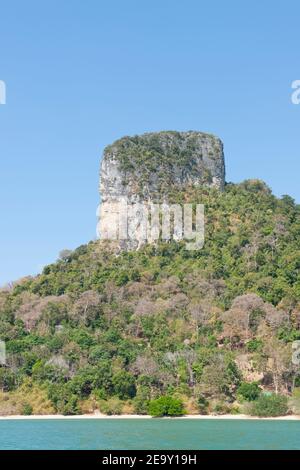 Una gigantesca formazione rocciosa si affaccia sulla sabbia bianca e sul mare blu di Railay Beach, a Krabi, Thailandia Foto Stock