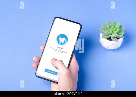 Melitopol, Ucraina - Gennaio 18 2021: Icona applicazione telegramma sullo schermo dello smartphone. Rete di social media online protetta. Sfondo blu Foto Stock