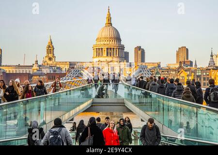 Folle di persone che attraversano il ponte pedonale London Millennium con Saint La Cattedrale di Paolo sullo sfondo Foto Stock