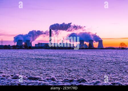 La mattina presto e un gelo duro sopra i campi agricoli in Drax, lo Yorkshire del nord. REGNO UNITO. Sole che sale verso est e percorsi di vapore acqueo da un Pow locale Foto Stock