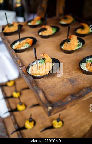 Tavolo per banchetti splendidamente decorato con vari antipasti di pesce e sandwich e antipasti di gamberi Foto Stock