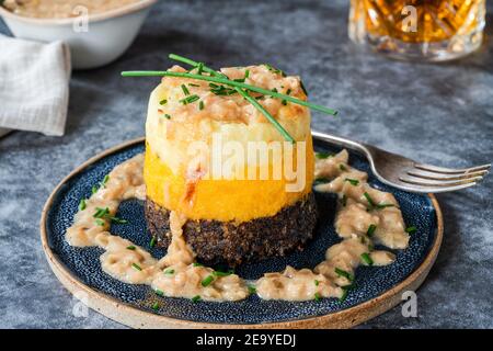 Haggis, neeps e taties stack (haggis con rape e patate) con salsa di whisky - piatto tradizionale scozzese per la notte dei Burns Foto Stock