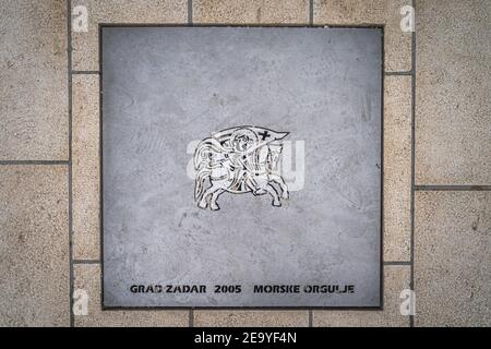 Zadar, Croazia, luglio 2019 organo marino, Morske orgulje, una piastrella di metallo segno con una scultura Foto Stock