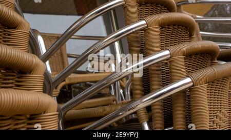Oggetti retrò, sedie con schienale in vimini accatastate in un mucchio nel ristorante chiuso durante la chiusura. Primo piano. Foto Stock
