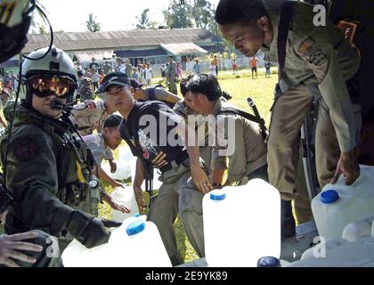 Schapp di Oakridge, Ore., e membri dell'esercito indonesiano scaricano caraffe di acqua purificate nell'impianto di distillazione a bordo della USS Abraham Lincoln (CVN 72). Gli elicotteri assegnati alla Carrier Air Wing Two (CVW-2) e i marinai di Abraham Lincoln stanno sostenendo l'operazione Unified Assistance, l'operazione umanitaria sulla scia dello tsunami che ha colpito il Sud-Est asiatico. Foto di Seth C. Peterson/USN via ABACA. Foto Stock