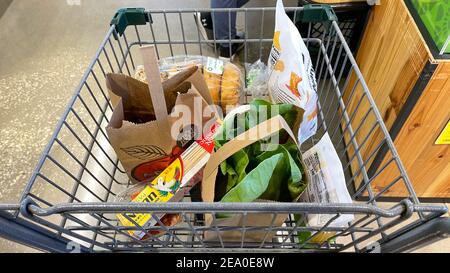 Orlando, FL USA - 18 gennaio 2021: Un carrello della drogheria con i generi alimentari in un negozio di alimentari Whole Foods Market a Orlando, Florida. Foto Stock