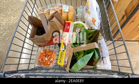 Orlando, FL USA - 18 gennaio 2021: Un carrello della drogheria con i generi alimentari in un negozio di alimentari Whole Foods Market a Orlando, Florida. Foto Stock